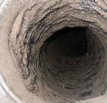 Technician clearing clogged dryer vent hose in O’Fallon Missouri