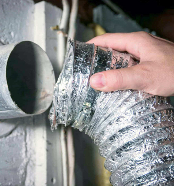 Technician using specialized vacuum to clean dryer vent for O’Fallon homeowner
